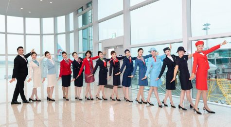 Korean Air cabin crew members showing off 11 different company uniforms. Over the past 50 years, there has been a total of 11 types of uniform, including the scarlet skirt and collarless uniform at its founding in 1969, the miniskirt-style uniform in 1970, the tailcoat-style red uniform in 1986, the dark blue jacket used for 14 years from 1991 and the current uniform with the color of celadon and beige since 2005. Image courtesy of Korean Air.
